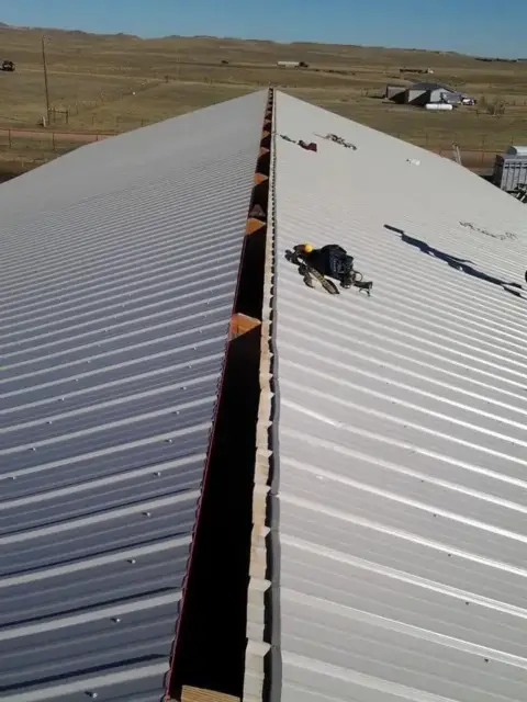 New metal roof panels with the ridge open, ready for the ridge cap
