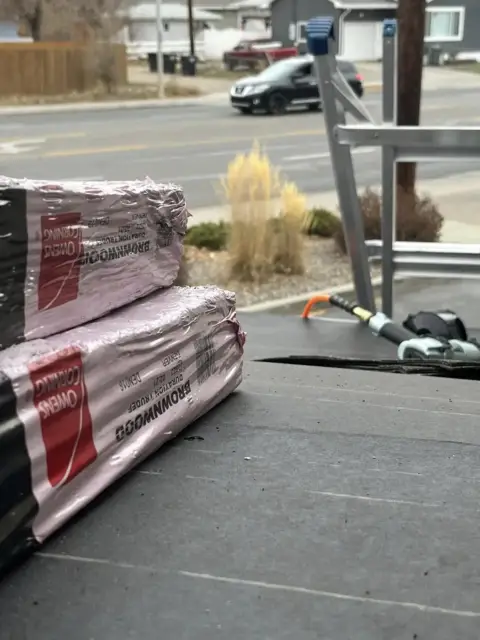Shingle bundles staged on a roof over fresh underlayment