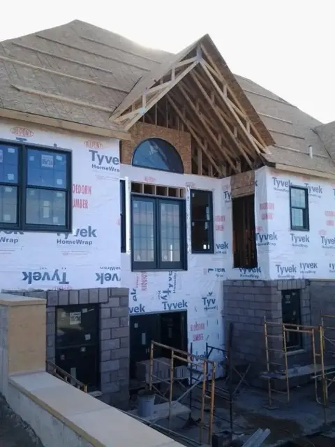 New-construction home wrapped in house wrap with the roof sheathed