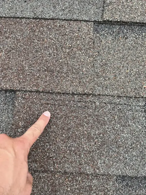 Close-up of shingle damage found during a roof inspection